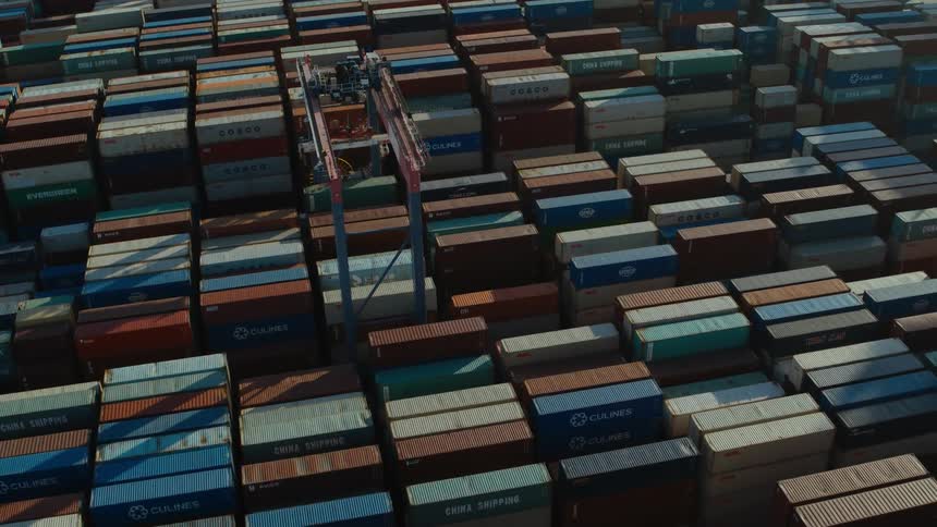 A machine is moving containers on a shipping dock