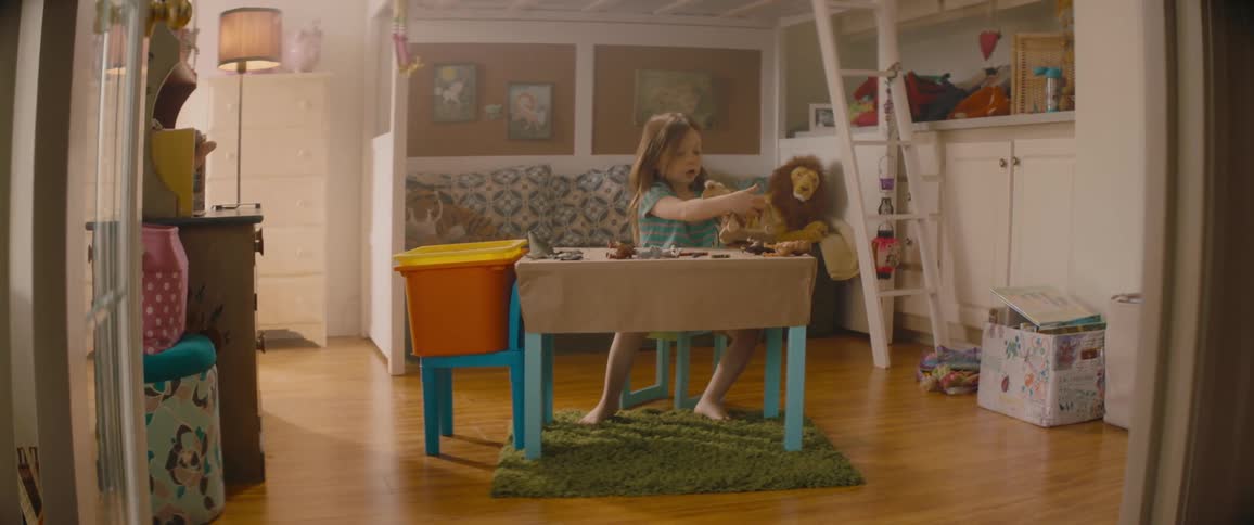 A little girl is sitting at her desk playing with her toys