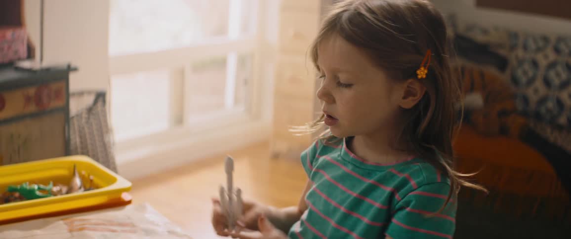 A young girl playing with a toy rocket