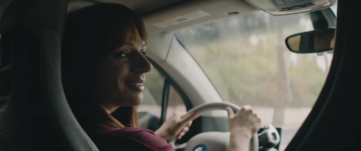 A woman driving a car down a road