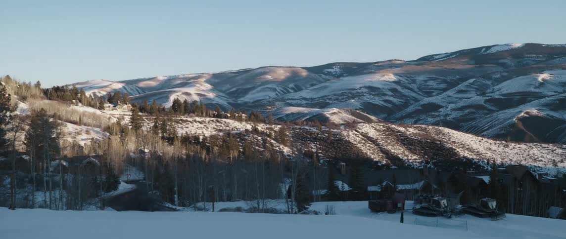 Buildings at the base of a snowy mountain range