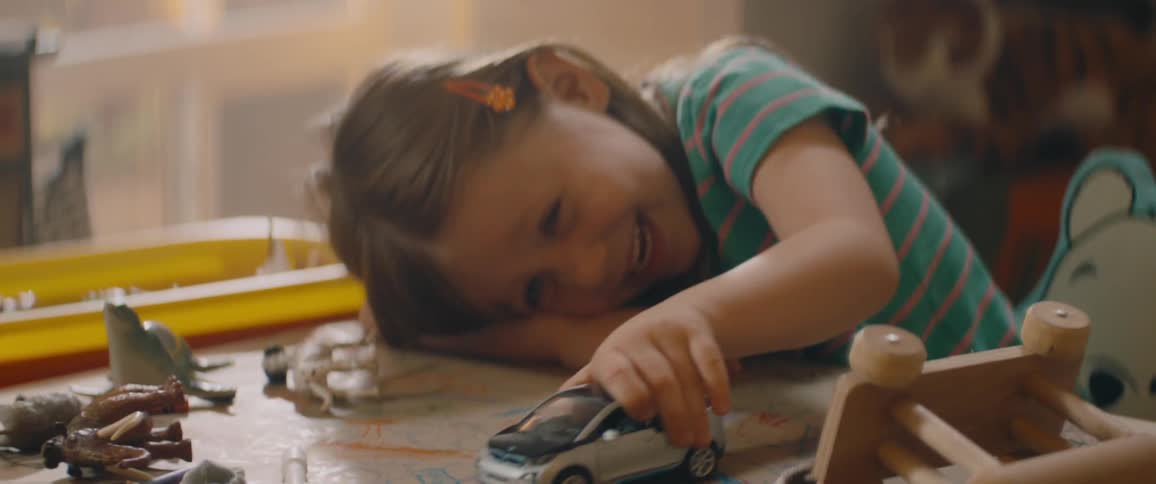 A child is playing with a toy car