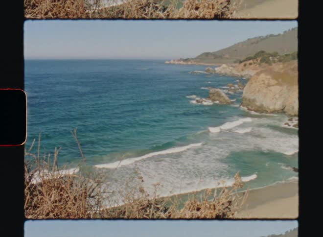 A small beach is lined with rocky cliffs as ocean waves wash upon it Big Sur California Super8 4k Film Scan