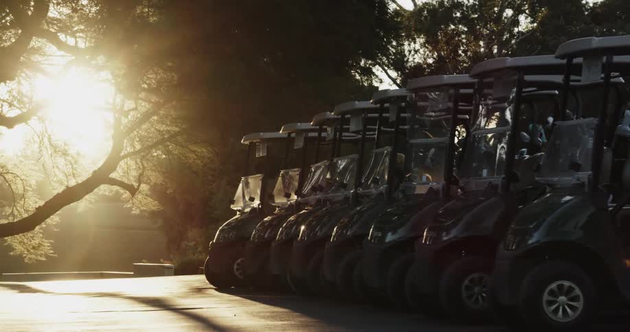The sun shines brightly on a set of golf carts