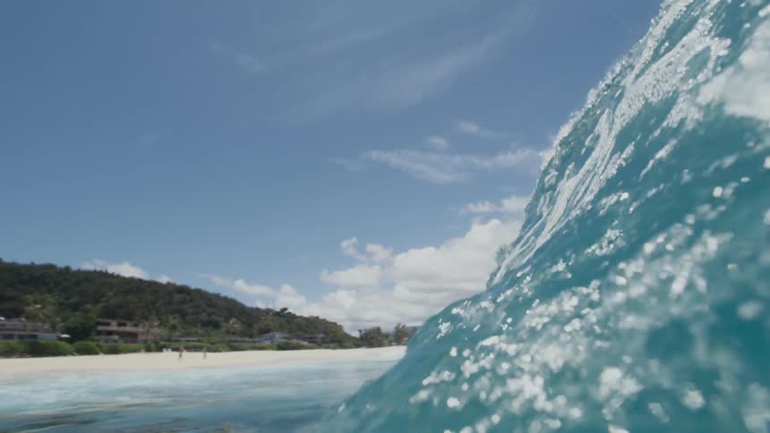 A big blue wave splashes as it rolls overhead and the view is now underwater