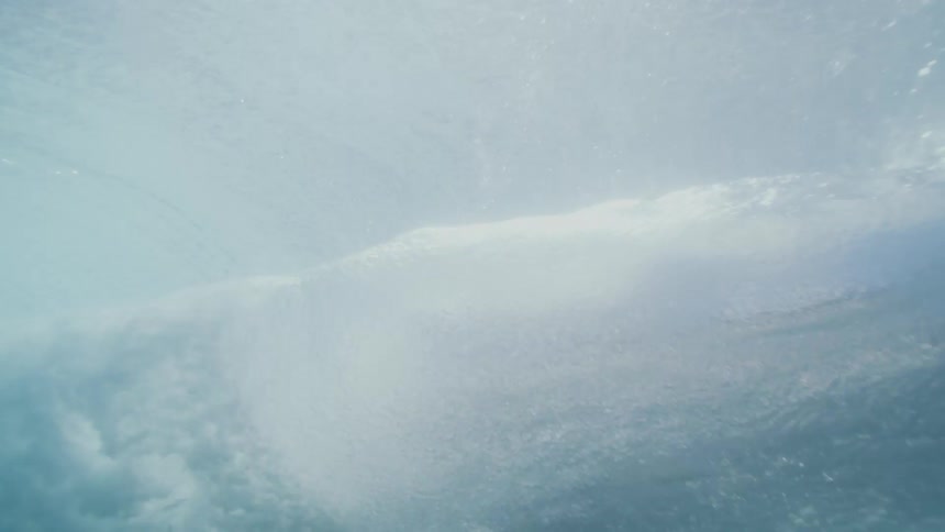 Swimmer wearing swim fins floats in the ocean on a body board