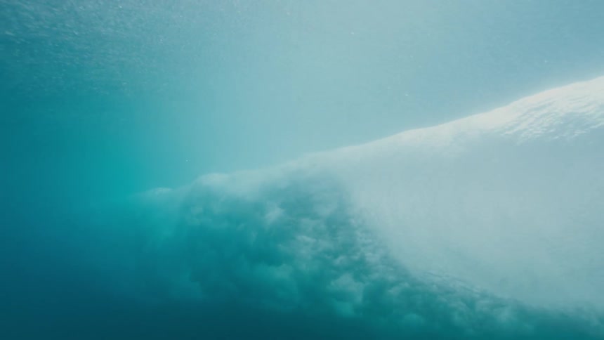 Ocean waves curling and rolling from underwater with sunlight shimmering