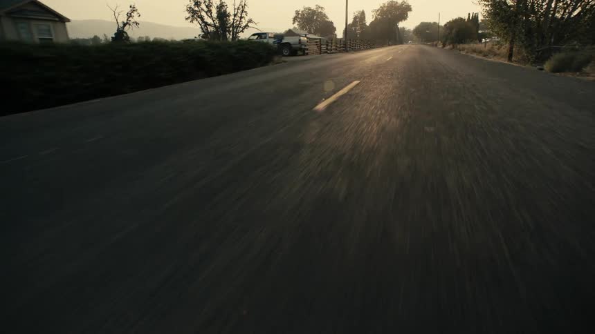 Traveling on a rural road with homes and farm animals behind fences