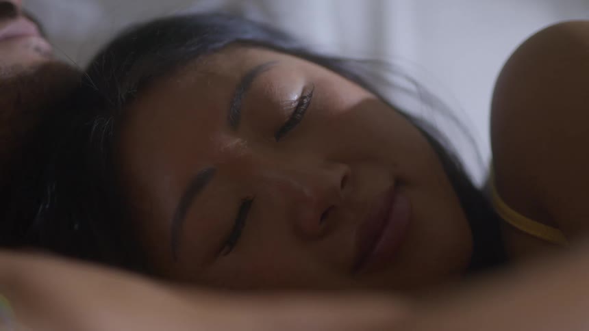A woman smiles as she wakes on her husbands chest