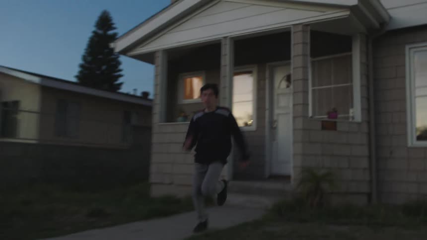 A boy races from the house