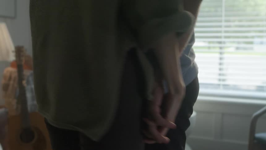 Couple dance and hold hands in living room