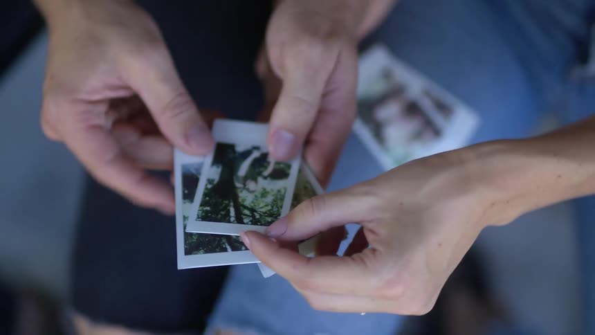 Man and woman sit sorting through photographs