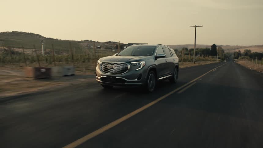 A black suv travels on a rural road