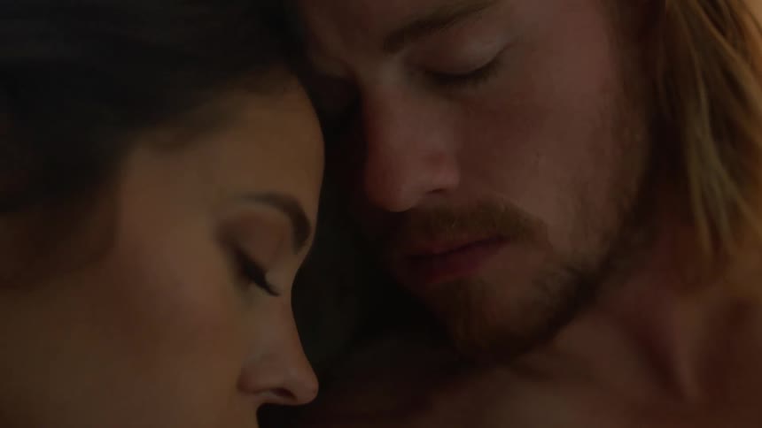 Bearded man turns his head to look at his sleeping wife