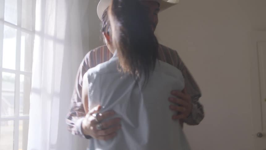 A couple dance and kiss at home