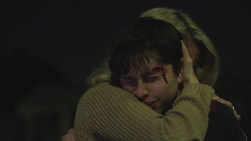 Mother hugs her injured son and comforts him at night