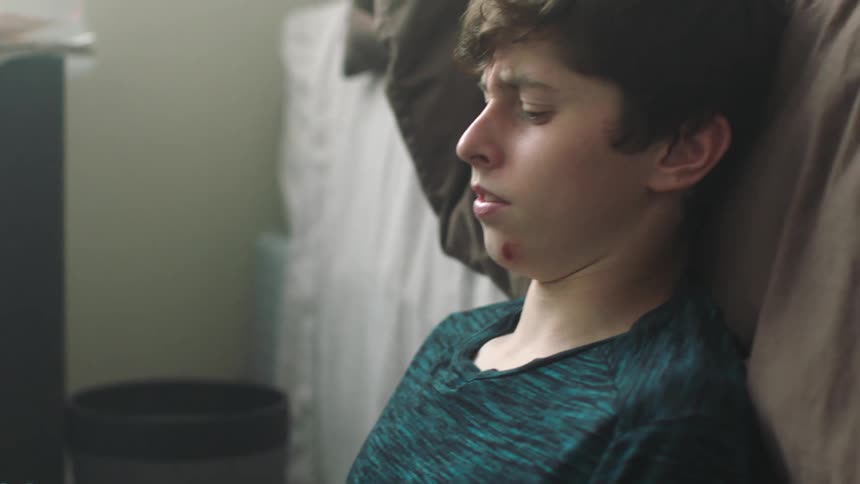 A boy throws a book in his bedroom