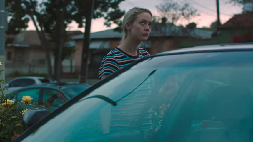 A woman with bruises on her face walks to a car and looks up anxiously before getting in