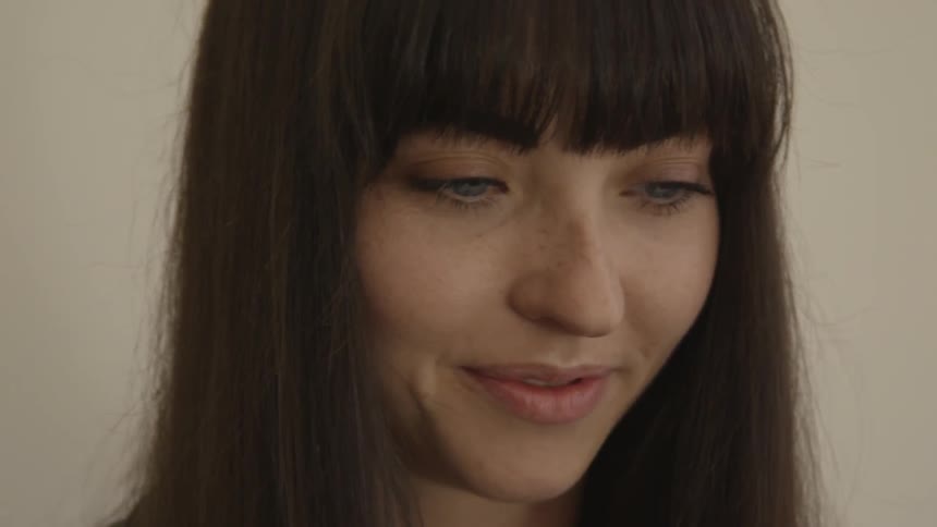 A woman with brown hair is smiling