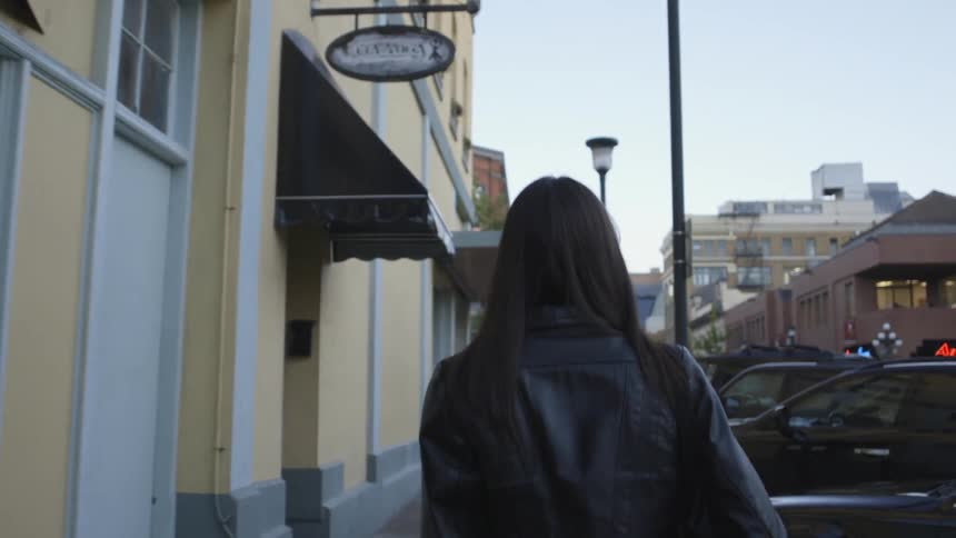 A woman is walking down a sidwalk