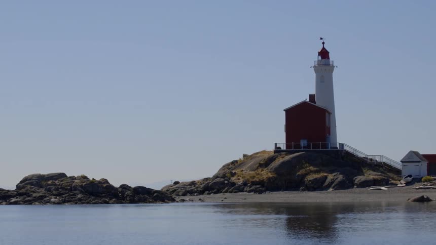 A lighthouse on the shore during a clear day