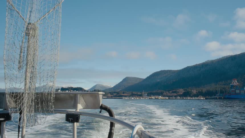 A fishing boat moves further from the coast