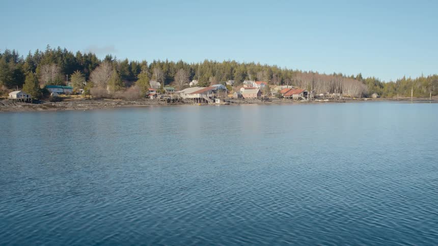 Small waves ripple through a lake in front of a neighborhood along the coast