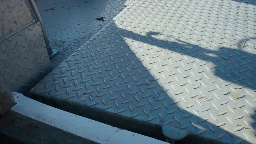 Boat equipment casts a shadow in the back of a boat deck
