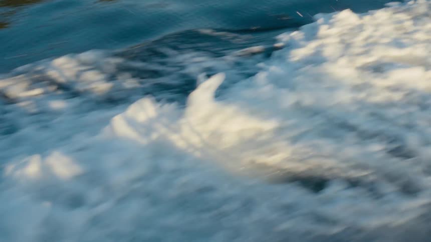 Shadow of boat being cast on wake in the ocean