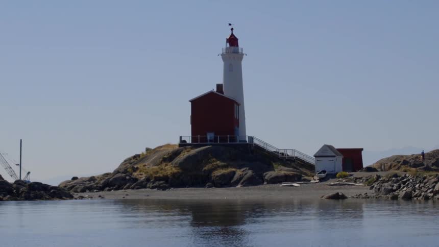 A lighthouse sits across the water on a sunny day