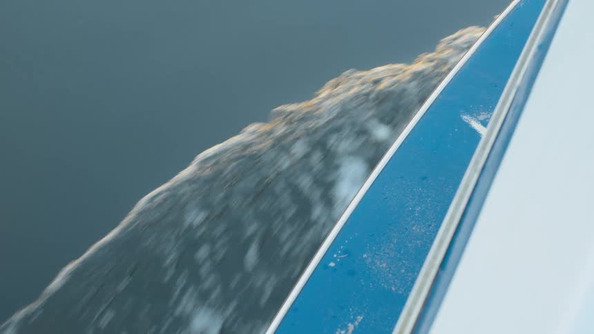 The hull of a boat displaces water as it travels across a body of water
