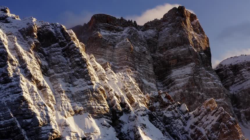 Snow on the sides of the mountains under a blue sky