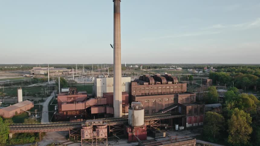 A tall smokestack standing above a power generation plant