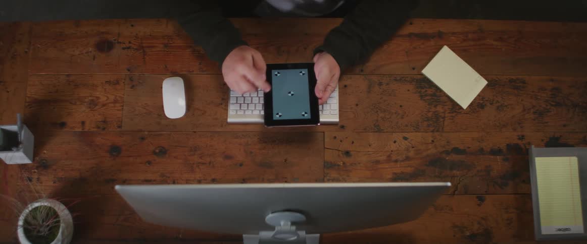 A person is sitting at a computer desk with a phone