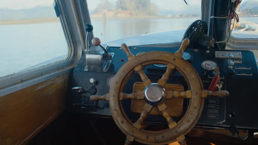 The empty cockpit of a boat traveling on auto pilot through the water