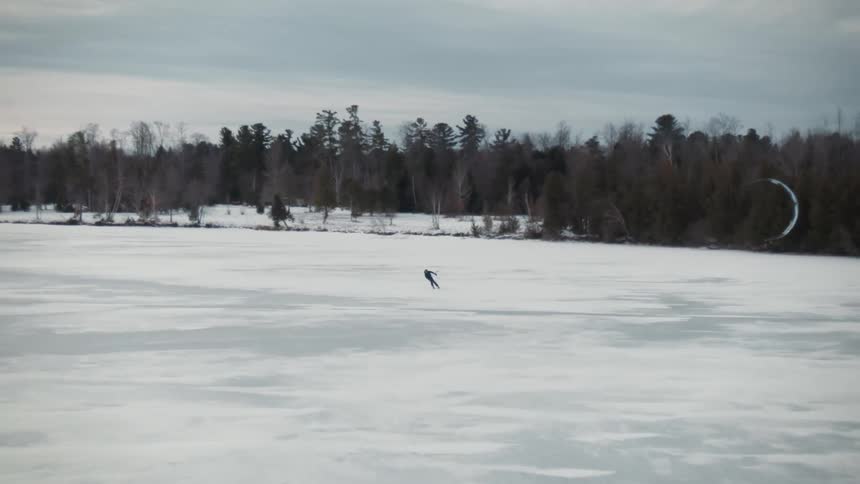 A person snowkiting on a frozen lake