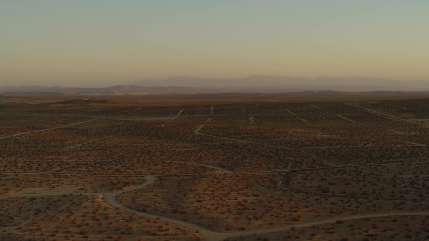Aerial view of a desert landscape is displayed at dusk