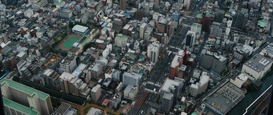 A wide road running through a dense metropolis during the day