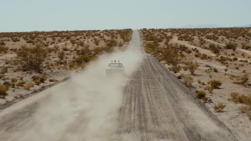 Aerial view of police cars driving on dirt road