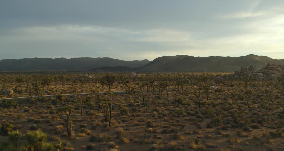 A vehicle drives down the highway in the desert