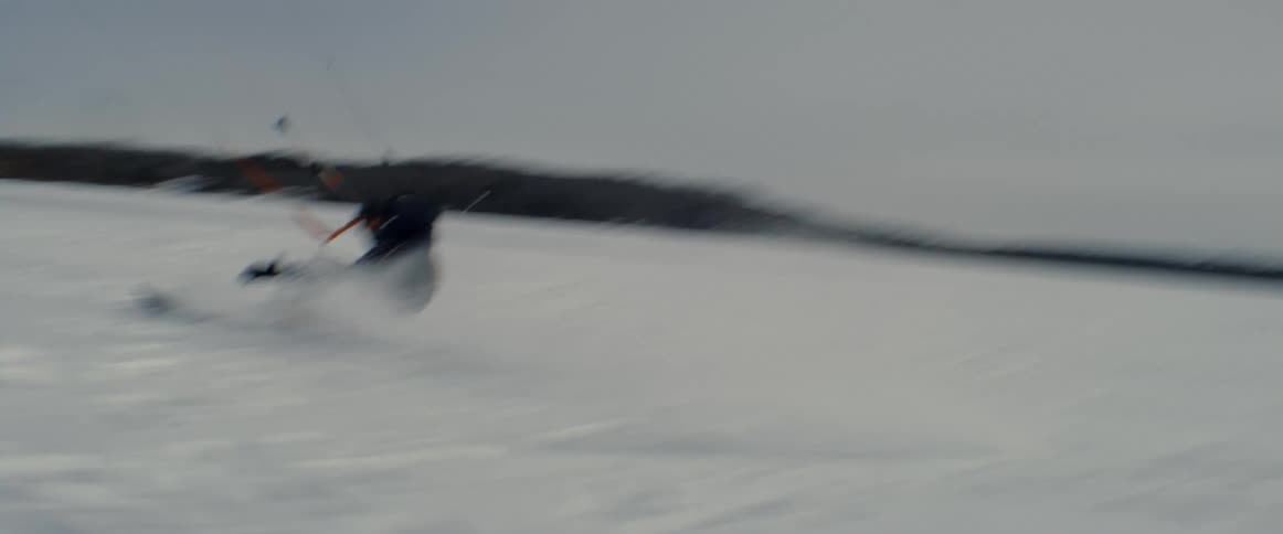 A person on skis is pulled along the snowy ground by a long cord that they are holding