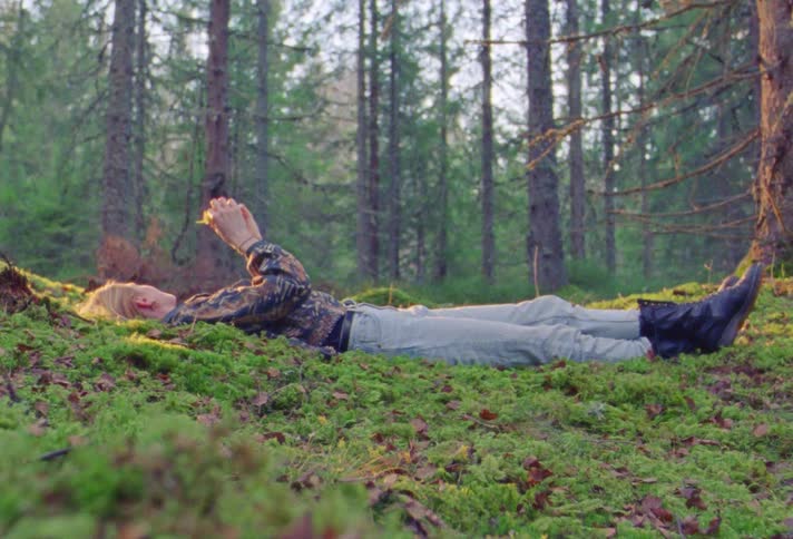 A woman is laying in the forest