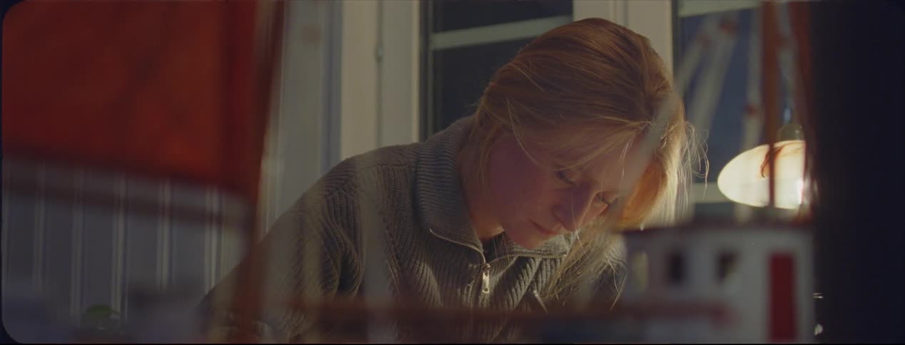 A woman is writing in her room
