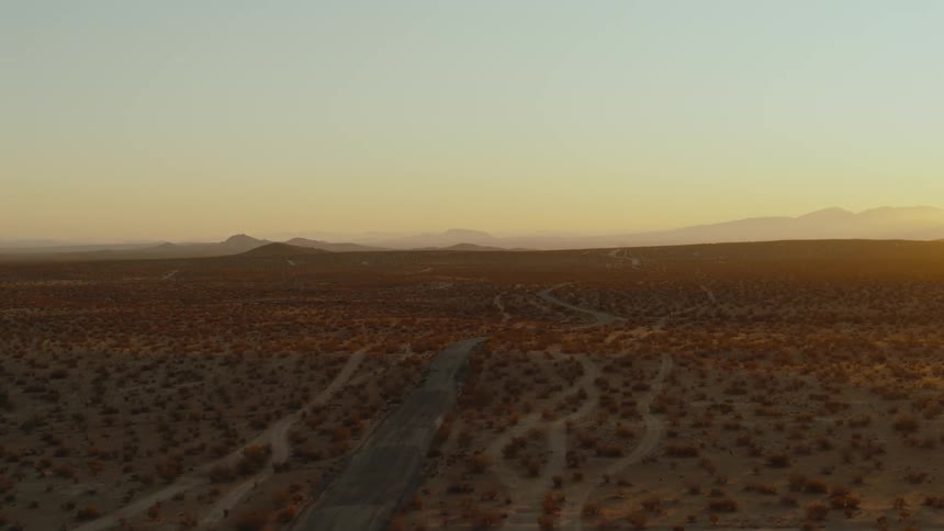 An aerial view of a road with wide open fields on both sides