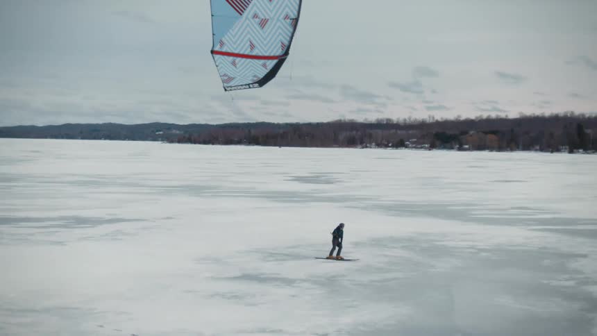 Skier speedriding on the snowy field with mountains in the distance