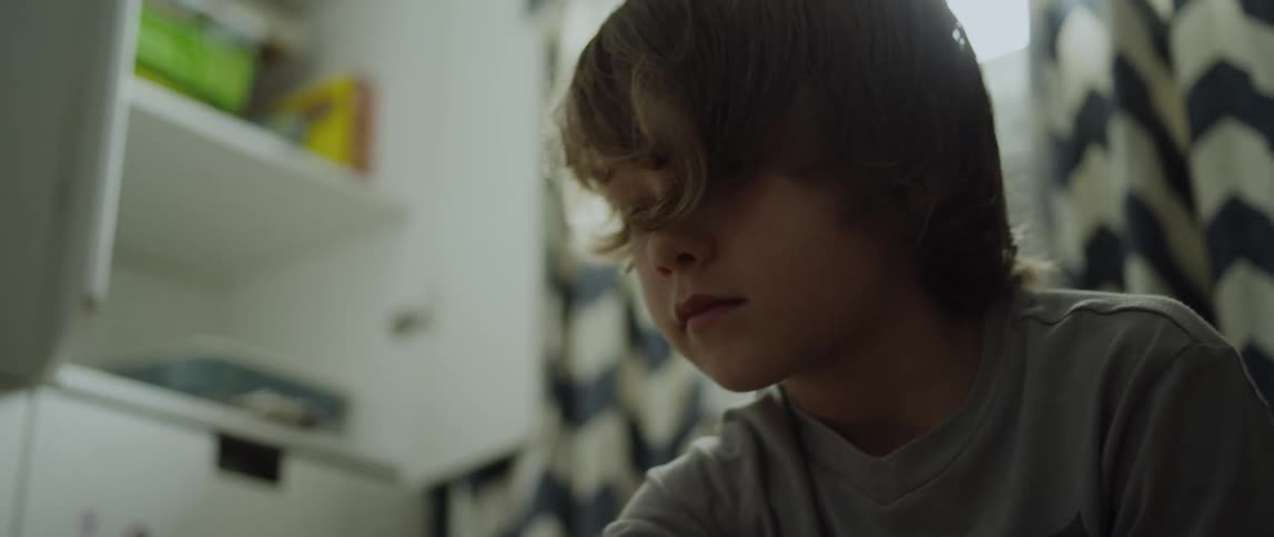 A young boy at home looks around a room