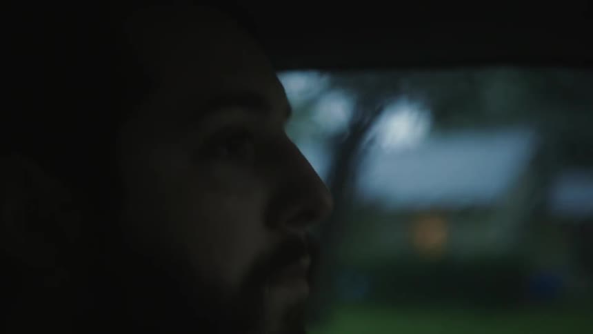 Close up of a man's face as he rides in a car