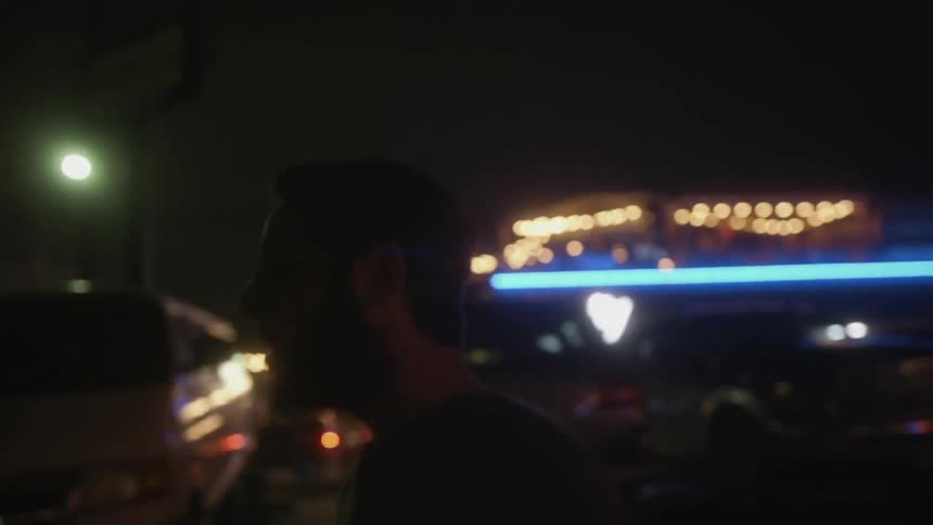 A man is walking outside at night
