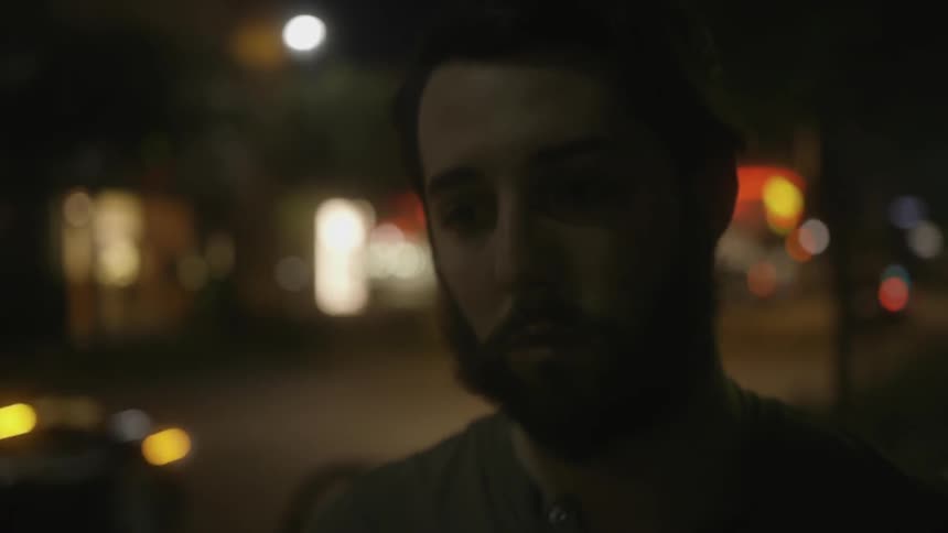 A man is walking outside at night