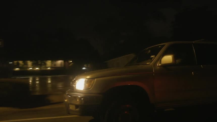 A car is racing down a road at night
